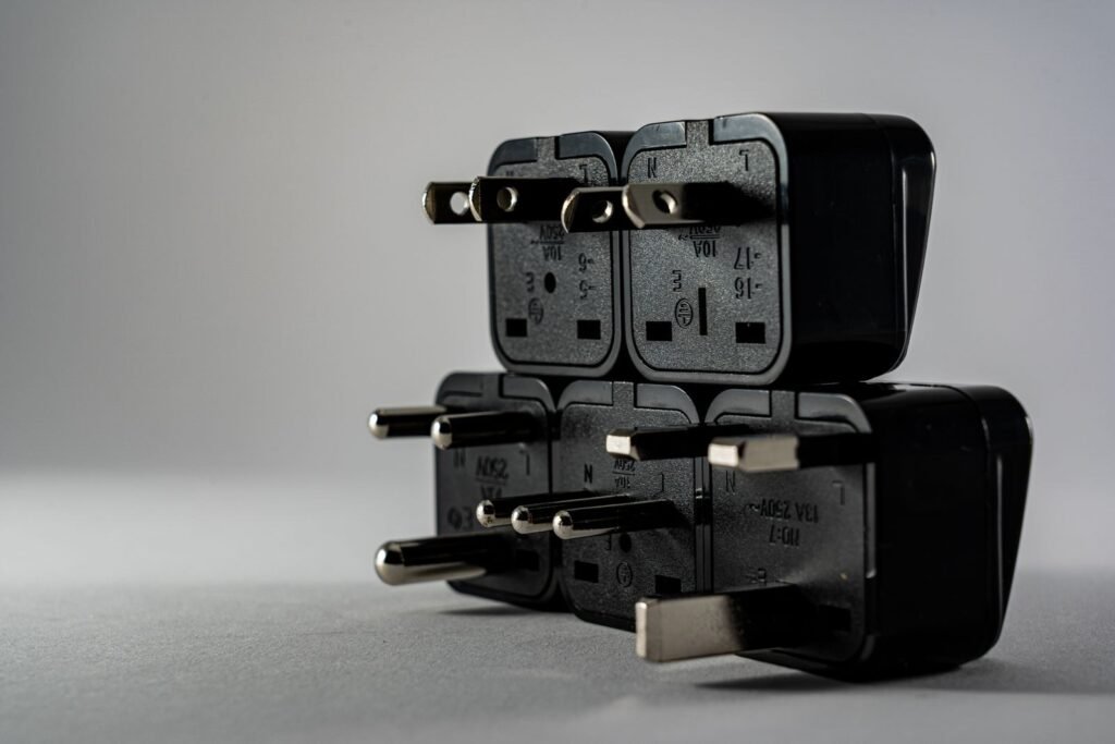 Photo by Castorly Stock Close-up of black electrical adapters stacked on a gray background.