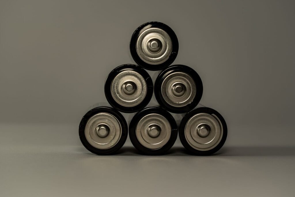 Photo by Castorly Stock Metallic AA batteries stacked in a pyramid shape, symbolizing power and energy storage.