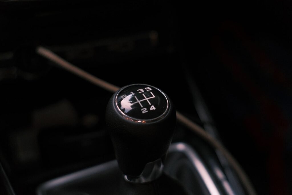 Detailed view of a car's manual transmission shift knob with visible gear pattern.