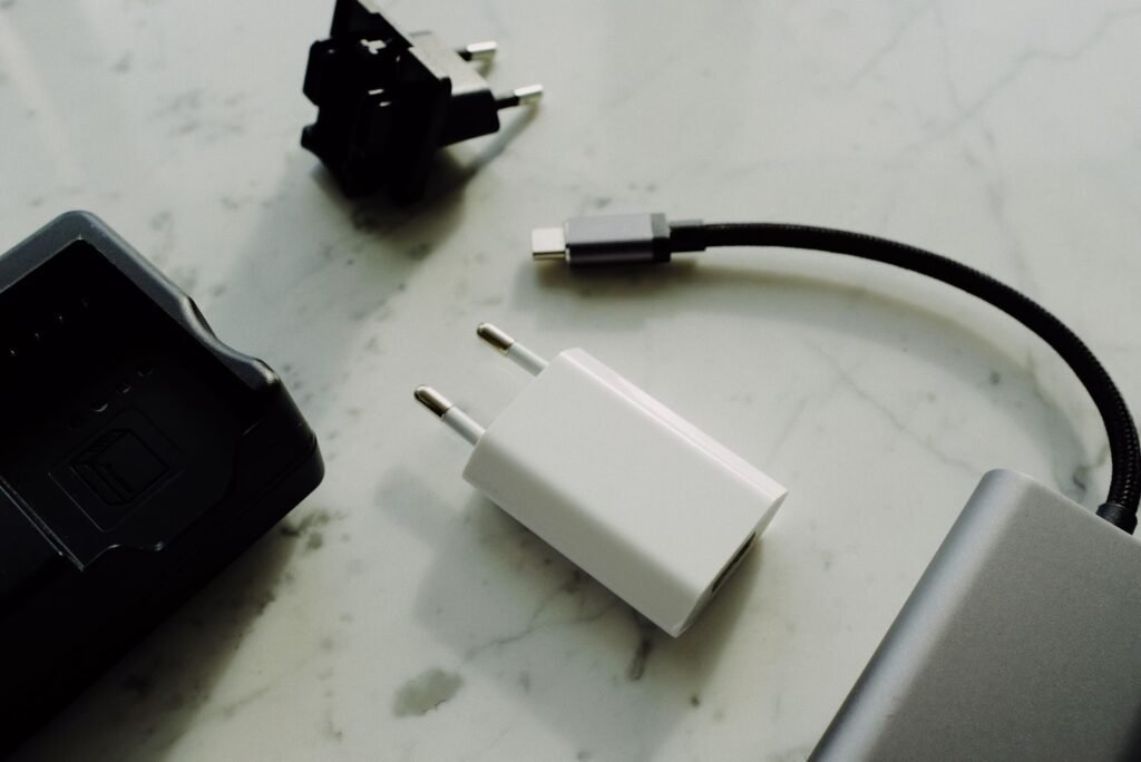 Photo by ready made Set of various modern charging unit with adapter and small external battery pack with short cable placed on white marble table