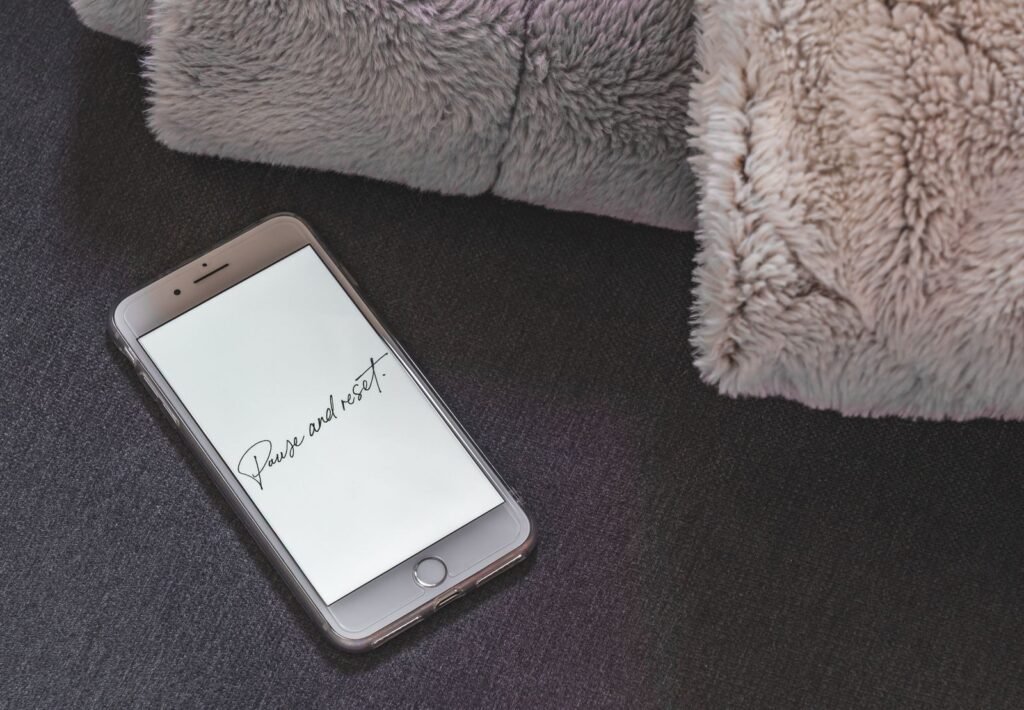 A smartphone on a soft surface showing 'Pause and Reset' on the screen.