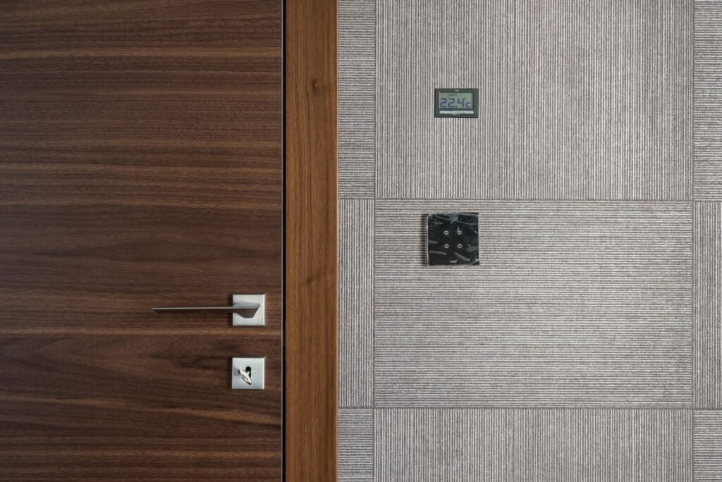 Sleek modern wooden door with stainless steel handle and 22.4°C display.