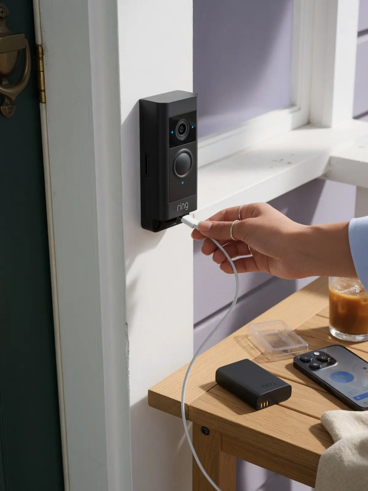 Ring doorbell battery charging guide with USB-C cable and spare battery on a front porch