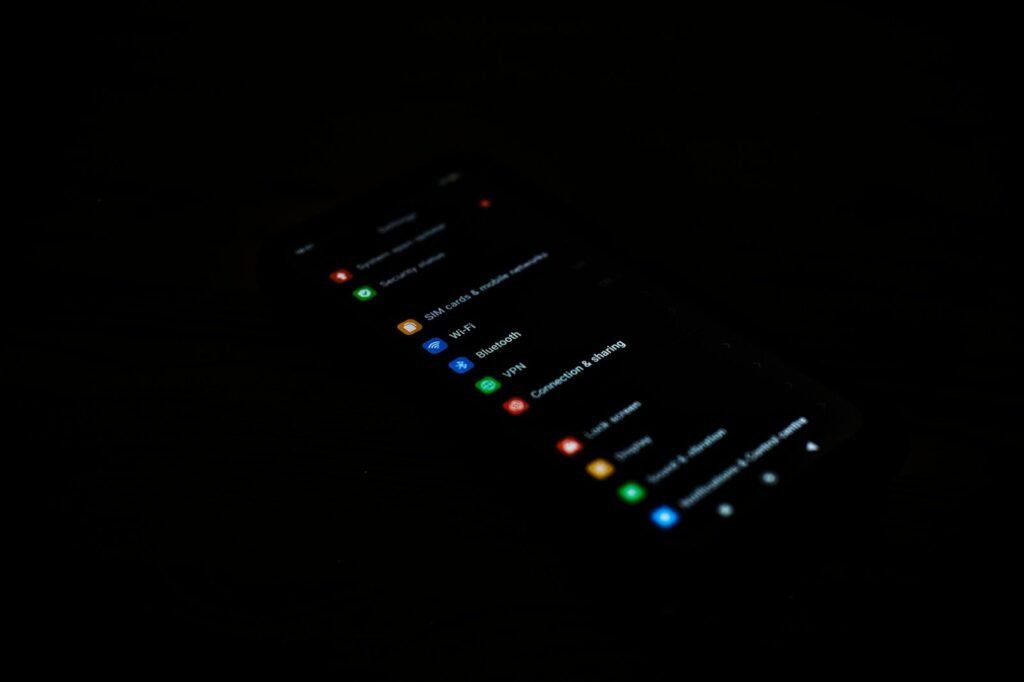A smartphone screen displaying app icons in darkness